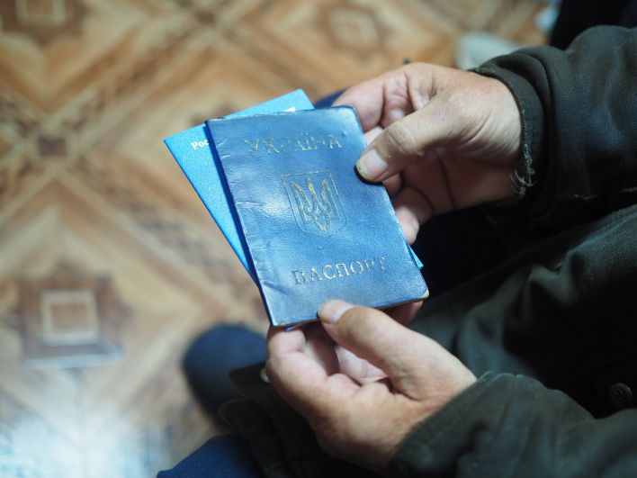 Пожилой мужчина держит в руках украинский паспорт, но любви к этому государству у него не осталось. 