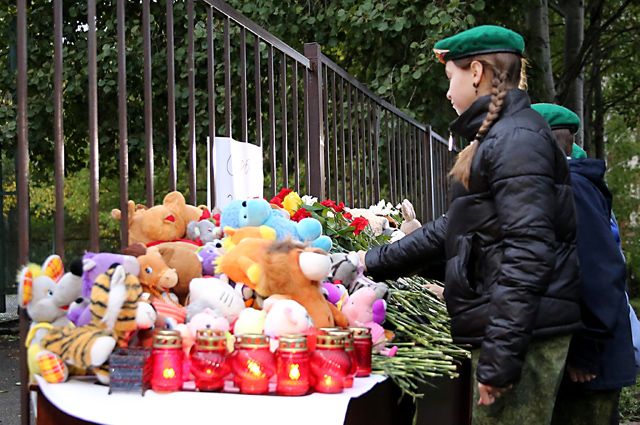 Люди возлагают цветы и игрушки у школы №88 Ижевска.