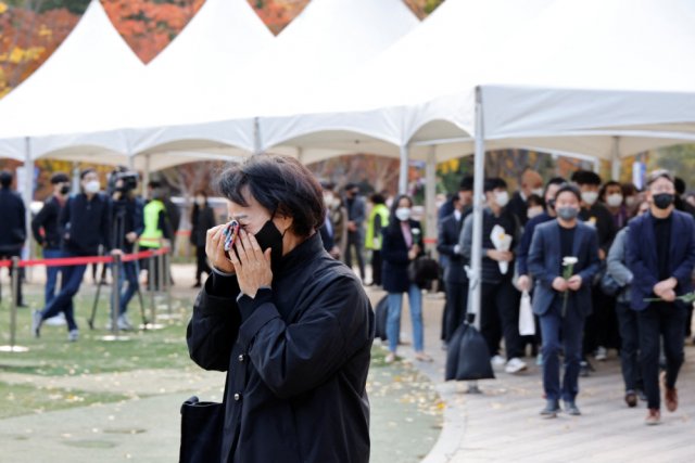 Человек скорбит у группового мемориала жертвам давки во время Хэллоуина на площади мэрии Сеула, Южная Корея, 31 октября 2022 года. 