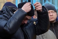 Призывник в украинскую армию на одном из призывных пунктов в Киеве (Украина) одевает нательный крестик.