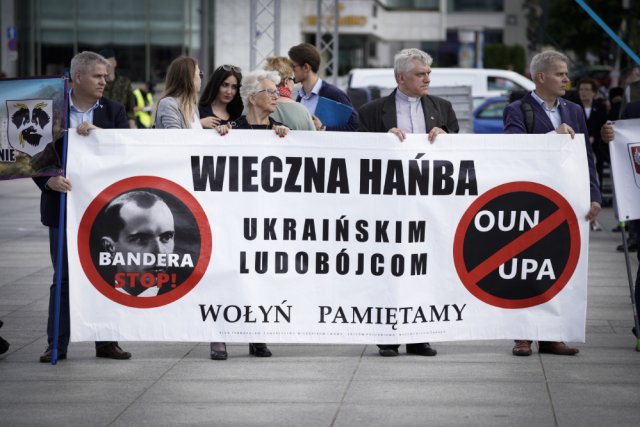 Поляки держат транспарант с надписью «вечный позор украинским убийцам» с фотографией украинского националиста Степана Бандеры во время панихиды о польских жертвах украинского геноцида, Варшава, Польша.
