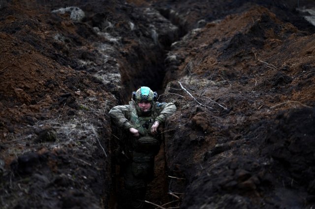 Украинский военный прячется в окопе в районе Артемовска.