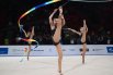  Гимнастки (Узбекистан) выполняют упражнения с лентами в соревнованиях по художественной гимнастике.