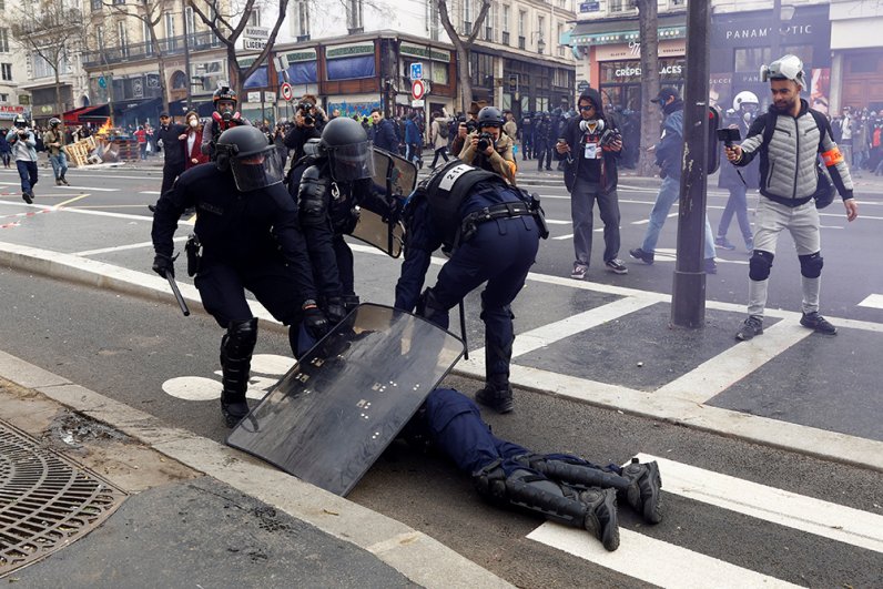 Полицейские прикрывают сотрудника полиции пострадавшего во время протестов.