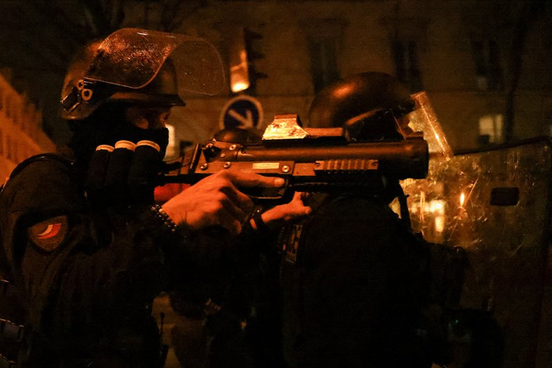 Сотрудник французской полиции по охране общественного порядка держит светошумовой пистолет во время демонстрации в рамках девятого дня общенациональных забастовок и протестов против пенсионной реформы французского правительства в Париже.