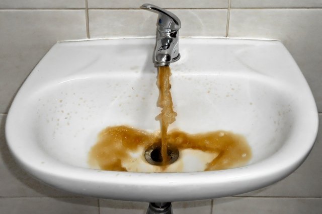 В воде после кипячения появляются белые хлопья, плёнка, а также она неприятно пахнет.