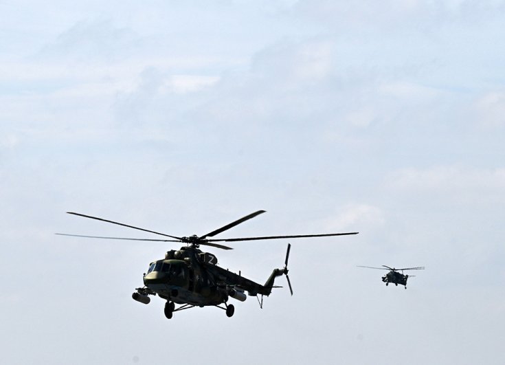 Вертолеты Ми-8 (слева) и Ми-28 ВС РФ в небе в зоне проведения специальной военной операции.