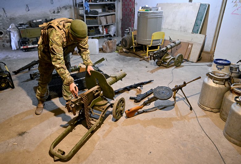 Боец ЧВК «Вагнер» демонстрирует трофейное оружие, найденное на позициях ВСУ в Артемовске. На переднем плане - пулемет Максима (в центре) и пулемет ДП-28 (справа).