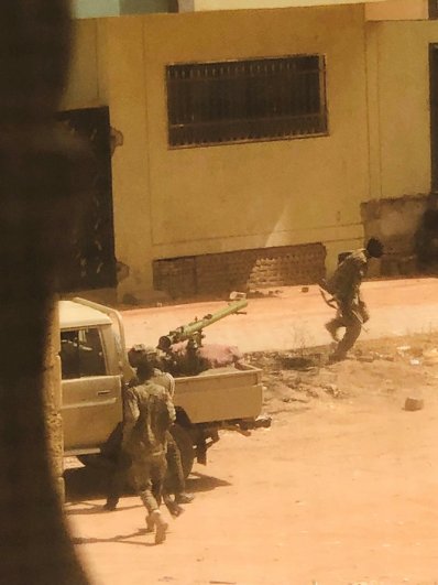 Военная машина и солдаты, предположительно из Суданских вооруженных сил, видны на улице в Хартуме.