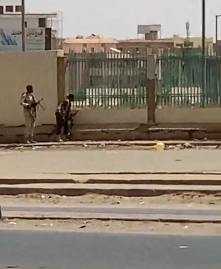 Двое вооруженных мужчин на улице в Хартуме.