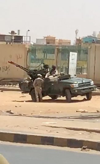 Военная машина и солдаты видны на улице Хартума.