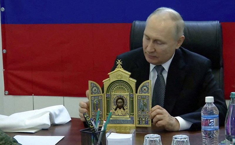 Владимир Путин вручает копию иконы военнослужащим во время посещения штаба группировки «Днепр» на Херсонском направлении специальной военной операции.