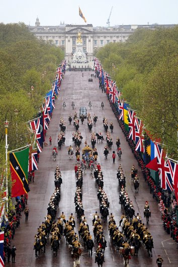 Государственная карета в сопровождении королевского эскорта из придворной кавалерии проезжает по аллее в составе королевской процессии перед церемонией коронации короля Карла III и королевы Камиллы в центре Лондона. 