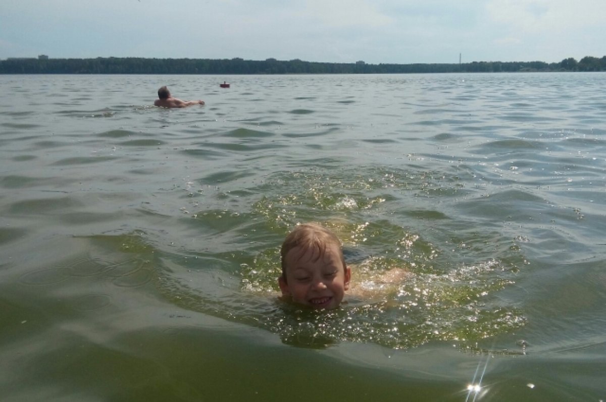 Дети купаются в озере. Купание в водоемах. Пляж на озере. На пляже купание.