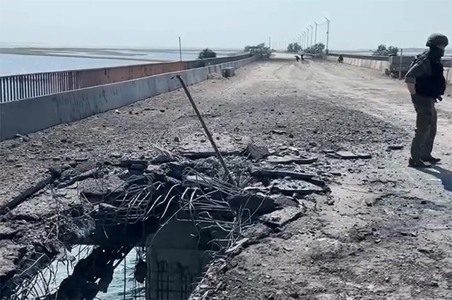 Сотрудник Следственного комитета РФ на поврежденной дороге на Чонгарском мосту, соединяющим Херсонскую область и Крымский полуостров, вследствие обстрела ВСУ.
