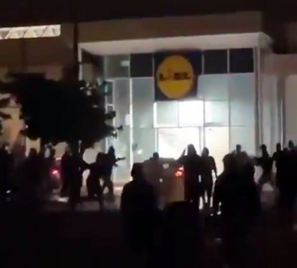 Демонстранты бьют витрины в супермаркета.