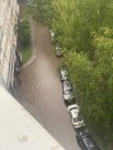 На улице Политбойцов. Жители сообщили, что днем 9 июля машины стояли в воде, мусорный бак поплыл, тротуар затопило..