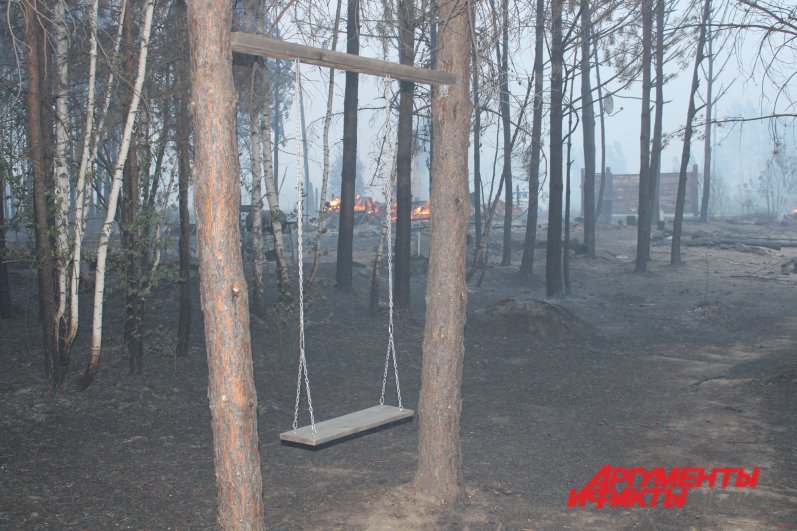 Деревянная качель во дворе, где еще пару часов назад стоял дом. Он сгорел, а качель осталась...