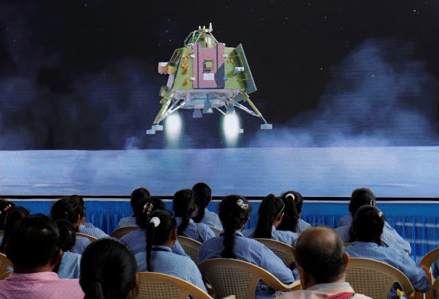 Люди смотрят прямую трансляцию посадки космического корабля «Чандраян-3» на Луну в аудитории Гуджаратского научного городка в Ахмадабаде, Индия, 23 августа 2023 года. 