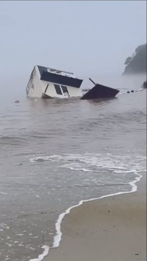 Смытый туристический домик прибило к берегу.