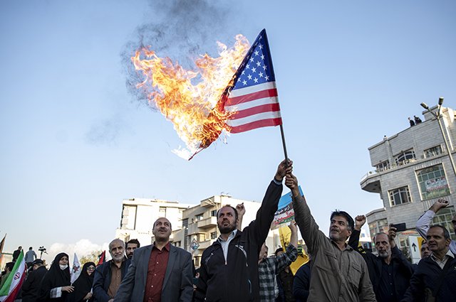 Иранцы сжигают флаг США во время антиизраильского митинга в Тегеране.