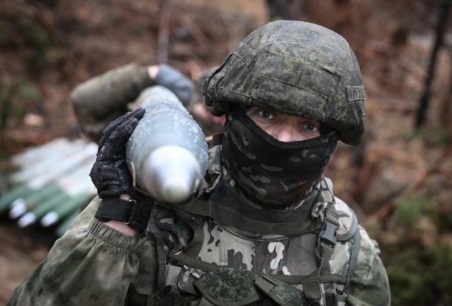 Солдаты русской армии переносят снаряд для РСЗО БМ-21 «Град» для стрельбы по позициям ВСУ.