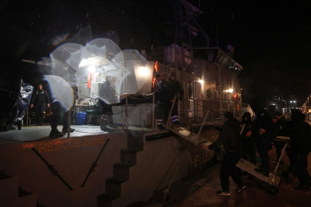 Офицеры и медики греческой береговой охраны во время спасательной операции после того, как судно затонуло у острова Лесбос, Греция, 26 ноября 2023 года.