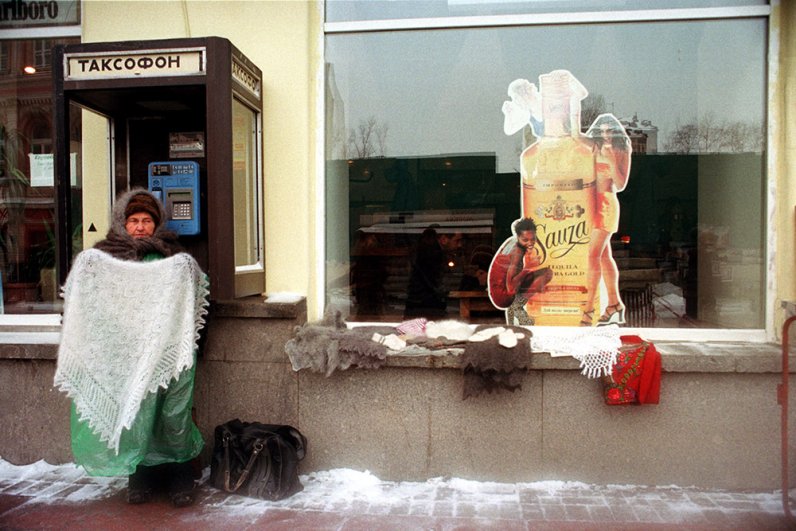  Ноябрь 1998 г. Женщина, продающая в с рук на улице пуховые платки, пытается таким образом преодолеть последствия финансового кризиса и дефолта, который ударил по России 17 августа. Начало бума карточных таксофонов в Москве – в 1995 г. их было 258 единиц, а в 1998 г. – почти 6 тысяч.