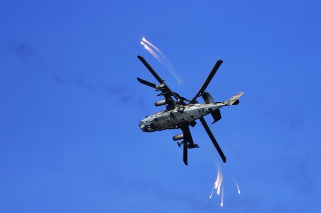Вертолет КА-52 отстреливает тепловые ловушки после стрельбы по позициям ВСУ.