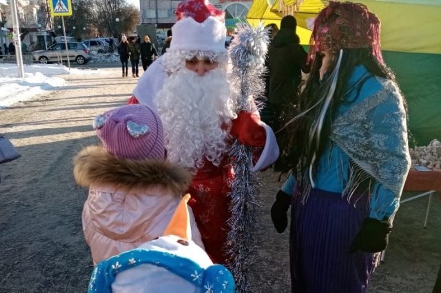 Марина Байгазина в костюме Деда Мороза раздаёт подарки детям. 
