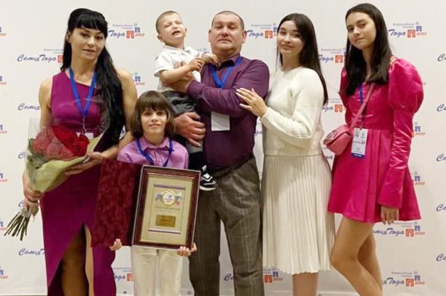 Чета Кузьминых с тремя дочерьми и внуком на церемонии награждения.