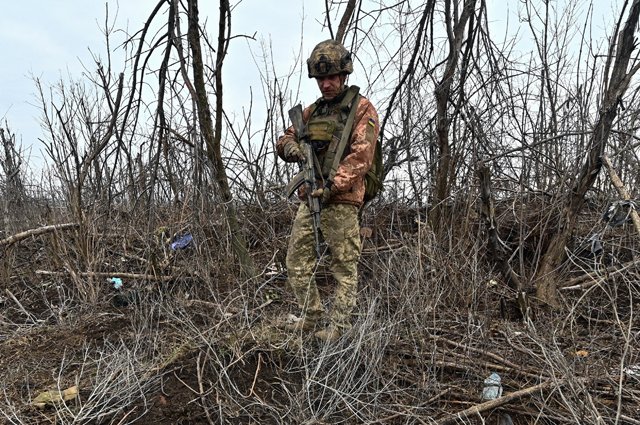 Солдат ВСУ осматривает место боестолкновения