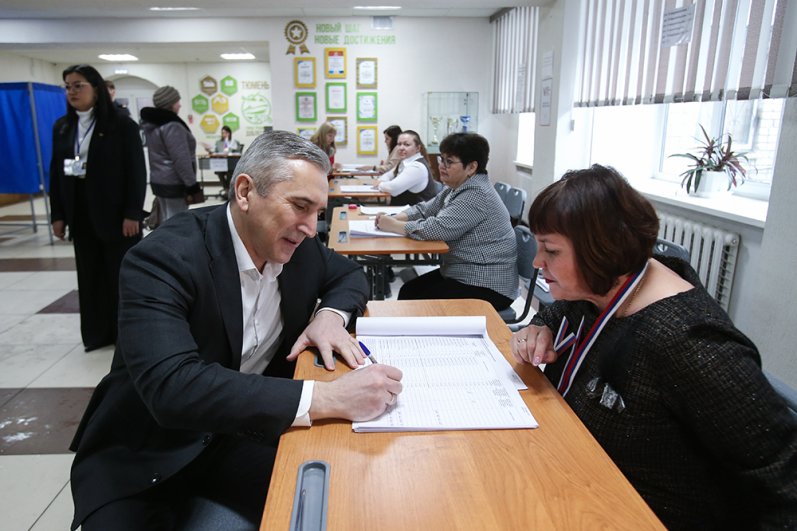 Губернатор Тюменской области Александр Моор получает бюллетень для голосования на выборах президента РФ на избирательном участке.