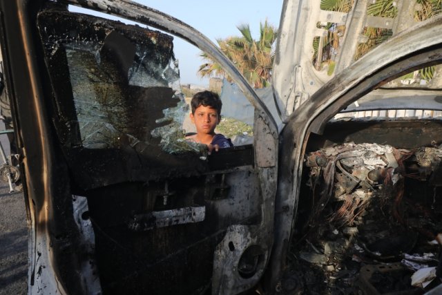 Арабский мальчик смотрит на взорванный израильскими военными автомобиль американской международной волонтерской организации помощи World Central Kitchen (WCK). Дайр-эль-Балах, сектор Газа, Палестина, 2 апреля 2024 г.