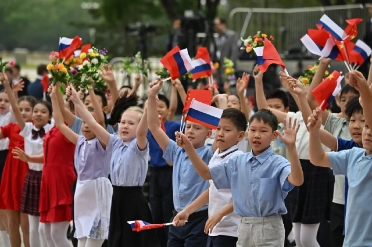 Китайские школьники встретили Путина в Пекине с цветами и флажками стран