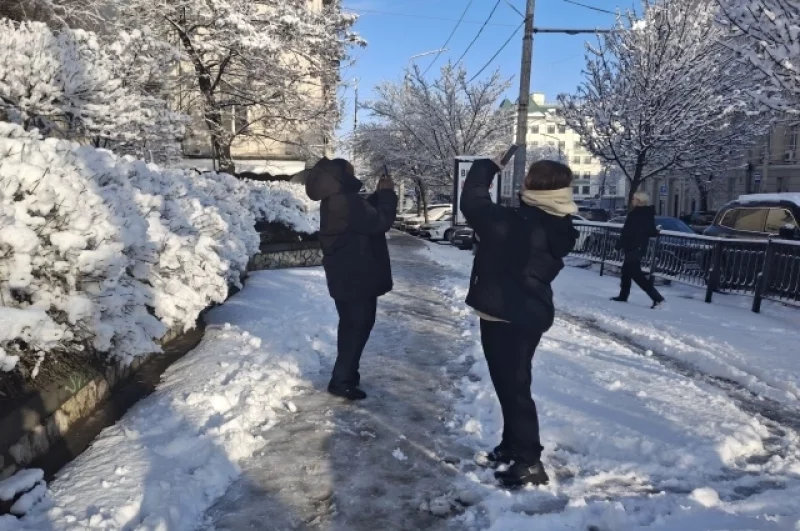 Девушки фотографируются на фоне зимних пейзажей.