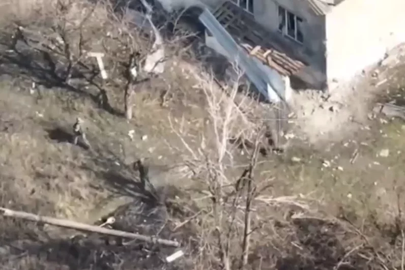 Из одного из ангаров выходят трое украинских военных, которые ложатся на землю и сдаются в плен.