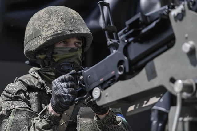 Военнослужащий зенитного расчета мобильной группы быстрого реагирования, вооруженный пулемётом ДШК, установленным в кузове УАЗа. Вооруженные силы РФ используют мобильные группы быстрого реагирования для защиты и противодействия атакам БПЛА.