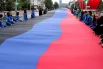 Активисты "Молодой гвардии "Единой России" развернули двухсотметровый флаг возле площади Ленина в Донецке ко Дню республики.