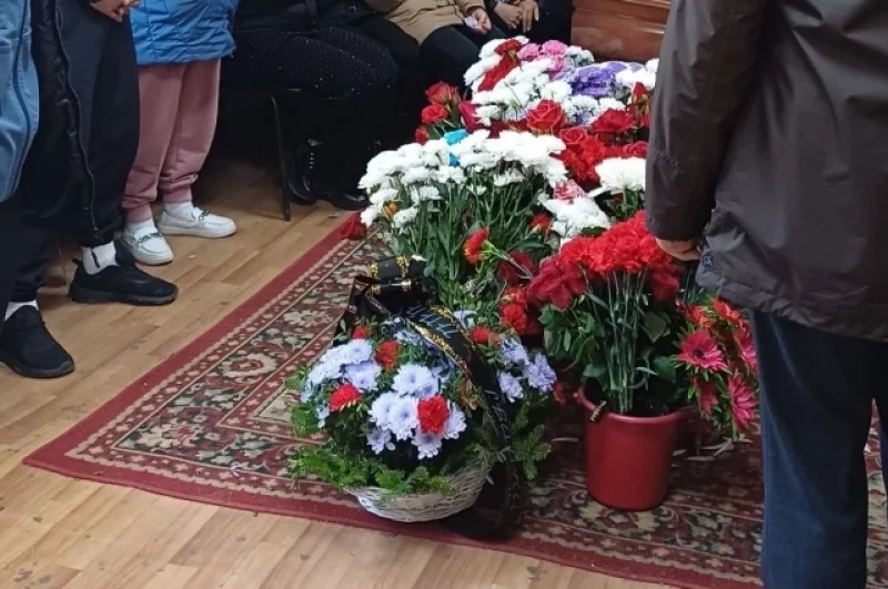 Родные, близкие и знакомые несут на прощание венки и цветы. 