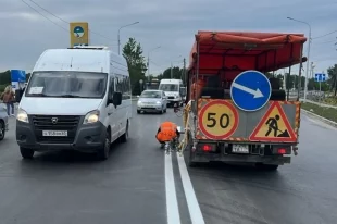 На отремонтированный участок дороги наносится разметка.