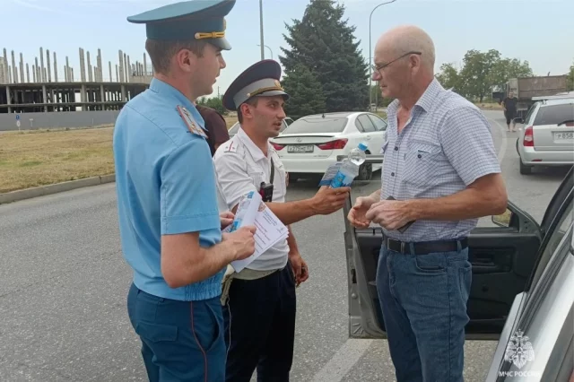 В КБР спасатели раздают водителям воду.