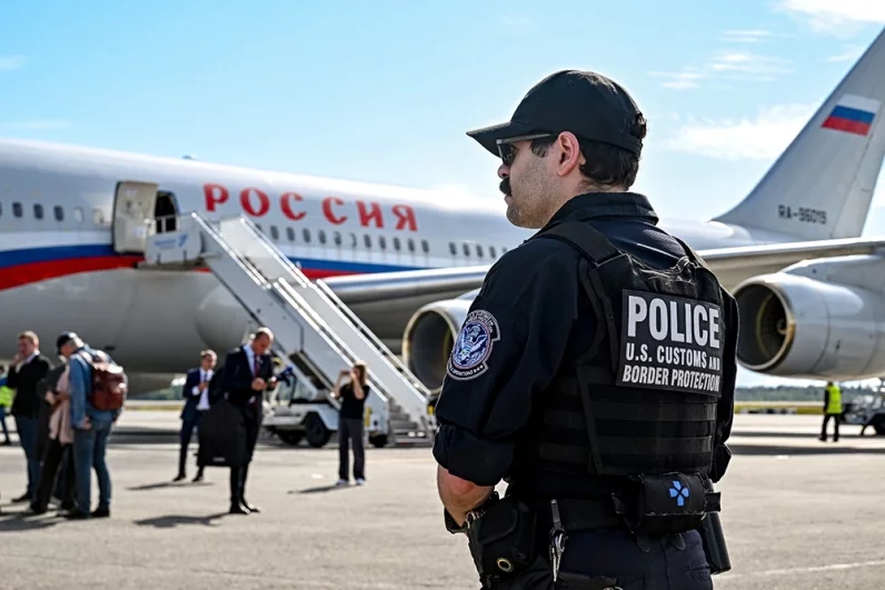 Сотрудник полиции на фоне самолета Ил-96-300 специального летного отряда «Россия» в Международном аэропорту Анкоридж. 15 августа в Анкоридже на Аляске пройдет встреча президента РФ Владимира Путина и президента США Дональда Трампа.