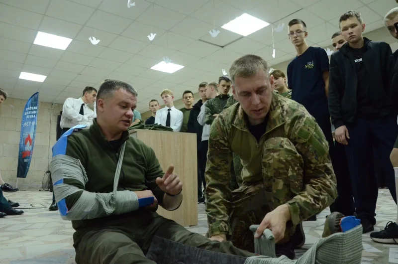 Ребятам показывают, как правильно иммобилизовать повреждённую ногу.