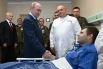 Президент РФ Владимир Путин во время посещения Центрального военного клинического госпиталя имени П. В. Мандрыка. Слева на втором плане – министр обороны РФ Андрей Белоусов; в центре справа – начальник Центрального военного клинического госпиталя имени П. В. Мандрыка Павел Крайнюков; справа – младший сержант МО РФ Руслан Колыванов.