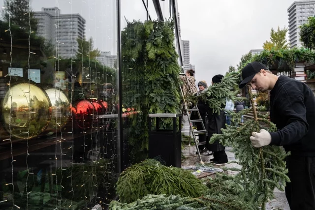 Сотрудники московского кафе украшают фасад к Новому году.