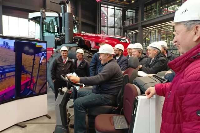 Белгородцы тестируют работу комбайна в ШоуРуме Тракторного завода в кабине-симуляторе.