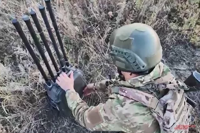 Боец ВС РФ разворачивает установку РЭБ. 