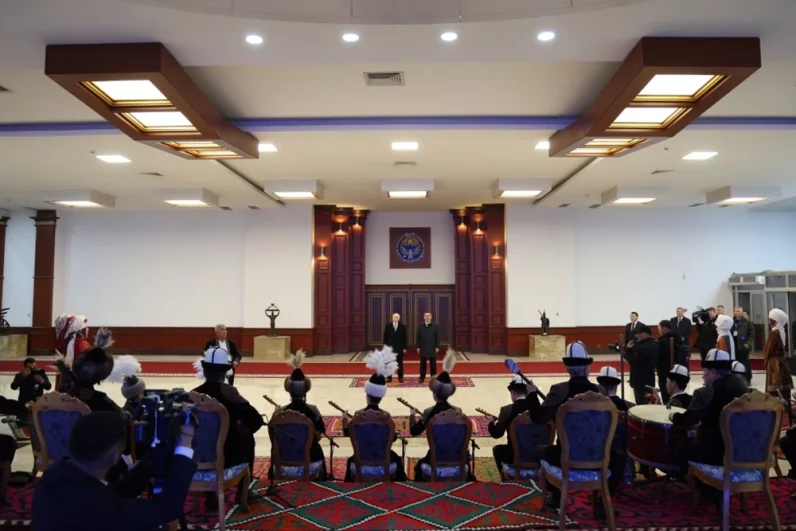 Президент РФ Владимир Путин и президент Киргизии Садыр Жапаров (справа) во время выступления фольклорно-этнографического ансамбля на церемонии встречи в аэропорту Бишкека Манас.