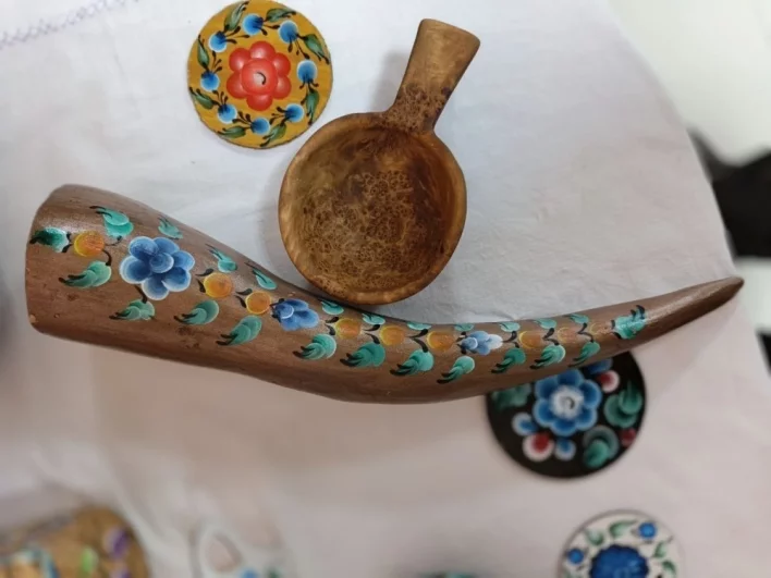 Мастер выпиливает изделия из капа и украшает их кармацкой росписью.